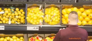 an employee stands infront of Sainsbury’s grocery store